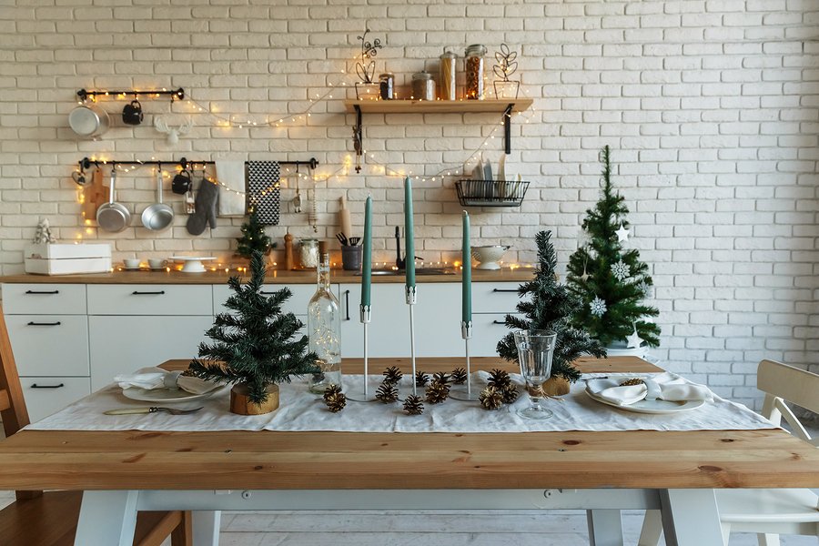 New Year and Christmas 2018. Festive kitchen in Christmas decorations. Candles, spruce branches, wooden stands, table laying.